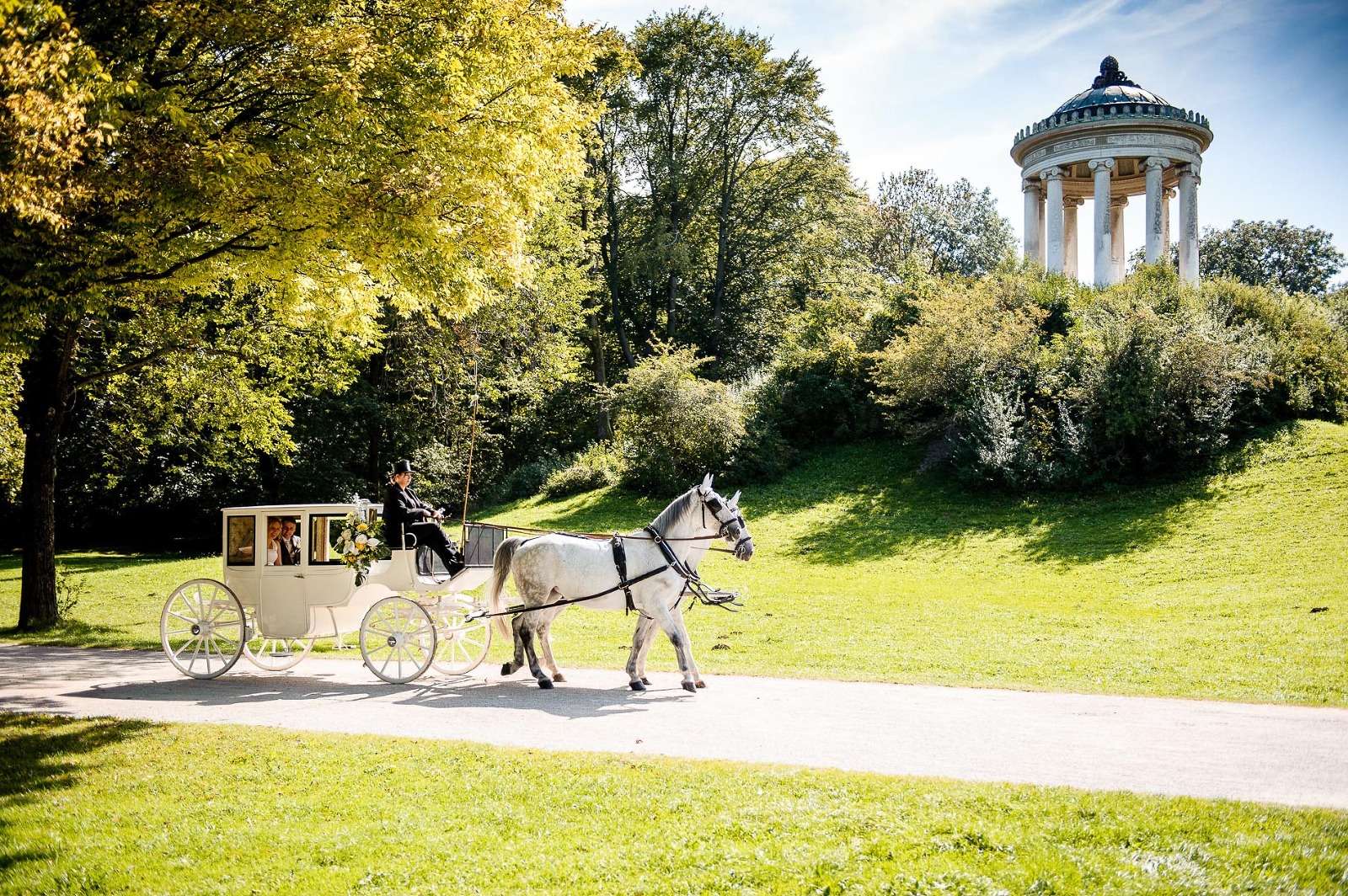 Fotograf München Hochzeit, Brautpaar in der Kutsche am Monopteros im Englischen Garten