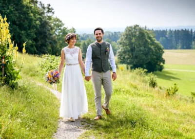 Brautpaar am Ammersee spaziert durch Schacky Park, festgehalten bei einer romantischen Hochzeitsreportage.