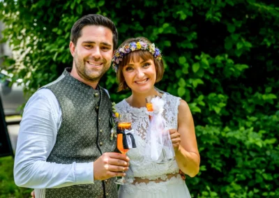 Brautpaar bei Hochzeitsfeier in Beuern bei Türkenfeld, lächelnd mit Sektgläsern. Hochzeit westlich von München.