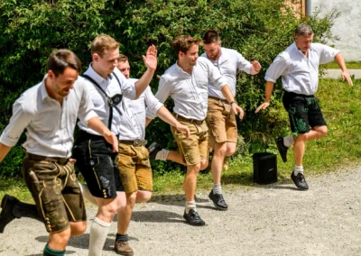 Tanzende Männer in Lederhosen bei einer Hochzeitsfeier in Beuern, Türkenfeld, traditionelles bayerisches Brauchtum.
