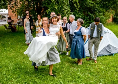 Hochzeitsfeier in Beuern bei Türkenfeld: Brautpaar mit Gästen in Tracht auf grüner Wiese, westlich von München.