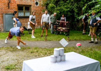 Hochzeitsfeier in Beuern, Türkenfeld: Gäste spielen Dosenwerfen im Freien, westlich von München.
