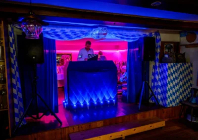 DJ legt Musik bei einer Hochzeitsfeier in Beuern, Türkenfeld, nahe München auf, blau-weiße Dekoration.