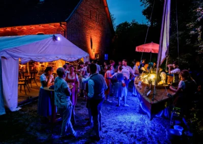 Hochzeitsfeier in Beuern bei Türkenfeld, stimmungsvolle Abendbeleuchtung, Gäste im Festzelt und am Segelbootbar.