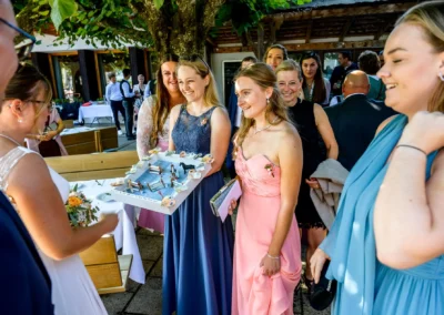 Hochzeitsfeier im Terrassenhof Bad Wiessee, Gäste überreichen Brautpaar Geschenk im Bootshaus am Abend.