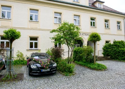 Hochzeitsauto mit Blumenschmuck vor Standesamt Schleissheim, idealer Ort nördlich von Muenchen fuer Trauungen.