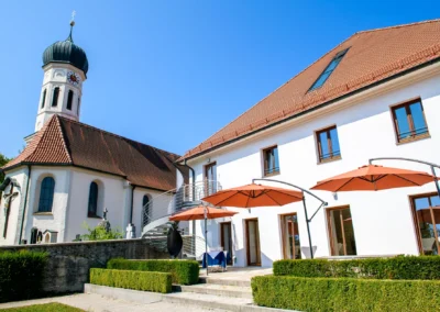 Standesamtliche Trauung in Poecking am Starnberger See, Kirche mit modernen Details im Sonnenschein.