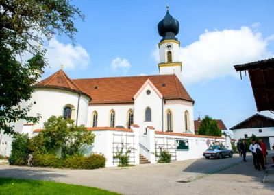 Kirchliche Trauung in Schonstett, Hochzeitsreportage mit barocker Kirche und blauen Himmel im Chiemgau.