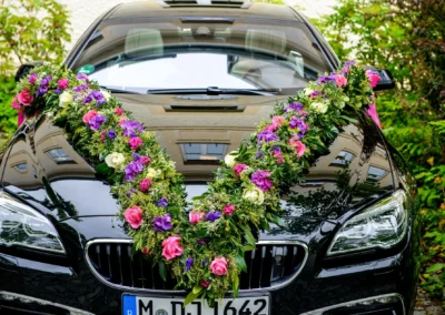 Hochzeit im Standesamt Schleissheim, geschmuecktes Auto mit Blumengirlande, Teil der Hochzeitsreportage.
