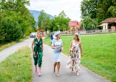 Gaste der Hochzeit in Fischbachau spazieren zur Martin-Luther-Kirche bei sonnigem Wetter.