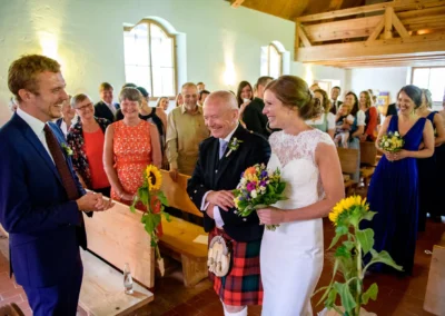 Brautpaar bei Trauung in Martin-Luther-Kirche Fischbachau, festlicher Moment mit Gaesten.