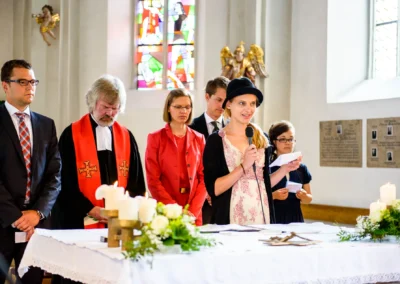 Kirchliche Trauung in Schonstett, Menschen am Altar bei Hochzeitszeremonie, Hochzeitsreportage, Chiemgau.