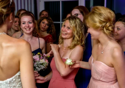 Frauen feiern auf Hochzeit im Hotel Aiterbach, Chiemsee, in festlicher Kleidung und mit Blumenstrauss.