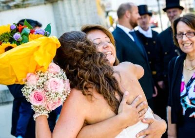 Umarmung bei standesamtlicher Hochzeit im Standesamt Fuerstenfeldbruck, leuchtender Blumenstrauss als Highlight.