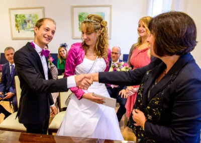 Brautpaar bei der Trauung im Standesamt Schleissheim umgeben von Gaesten, festliche Hochzeit, nördlich von München.