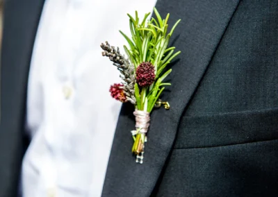 Anzugdetail mit Blumenanstecker bei freier Trauung auf Schloss Hohenkammer. Hochzeit, Anzug, Reportage.