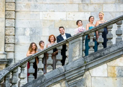 Brautpaar mit Begleitern posiert auf steinerner Treppe in Muenchen, Hochzeitsfotografie Friedensengel.