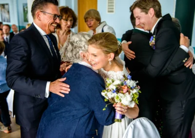 Braut umarmt Frau bei einer Hochzeitsfeier in Starnberg, emotionaler Moment der Trauung, Hochzeitsreportage.