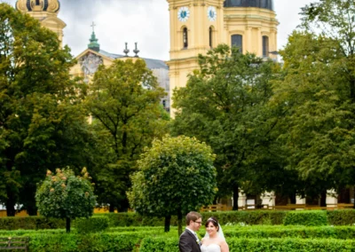 Brautpaar-Fotosession im Hofgarten Muenchen, elegant und romantisch, umgeben von Blumen und historischer Architektur.