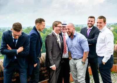 Männer lachen bei einer Hochzeitsfeier in Dachau. Fröhliches Gruppenfoto mit Freunden bei der Trauung.