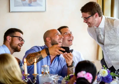 Gäste lachen bei einer Hochzeitsfeier im Zieglerbraeu, Dachau. Candelight Dinner bei der Trauung. Hochzeitsreportage.