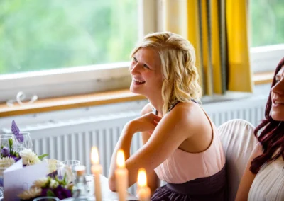 Gedeckter Hochzeitstisch mit Kerzen im Zieglerbraeu bei Hochzeitsfeier, lachende Gaeste.