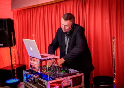 DJ bei Hochzeitsfeier mit rotem Vorhang in Zieglerbraeu Dachau, festliche Trauungsreportage.