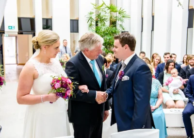 Brautpaar und Gaeste bei freier Trauung auf Schloss Hohenkammer, Hochzeit mit Blumenstrauss und Gratulation.