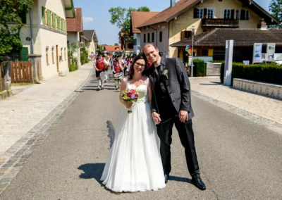 Brautpaar bei standesamtlicher Trauung in Poecking am Starnberger See, umgeben von traditioneller Musikgruppe.