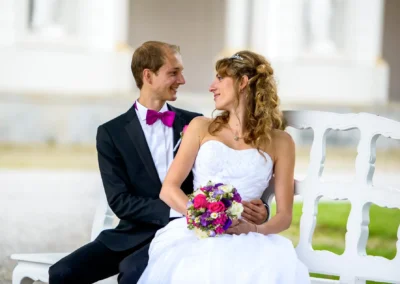 Brautpaar auf Bank bei Hochzeit im Schloss Schleissheim, romantischer Moment fuer Trauung nördlich von München.