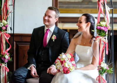 Brautpaar bei Trauung in Schloss Seefeld, westlich von Muenchen, laechelnd mit Blumenstrauss in Hochzeitsreportage.