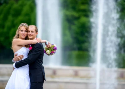 Brautpaar umarmt sich vor Springbrunnen bei Hochzeit im Schloss Schleissheim, romantische Trauung nördlich von Muenchen.