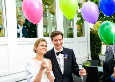 Brautpaar mit bunten Luftballons bei Hochzeitsfeier am Starnberger See, festgehalten in Hochzeitsreportage.