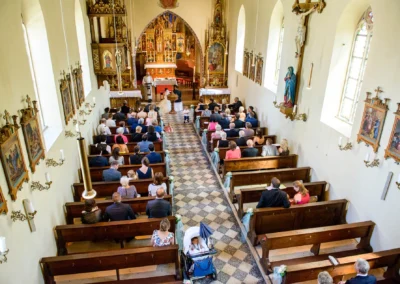 Kirchliche Hochzeit in der Dorfkirche St. Martin in Germering, naehe Muenchen. Verziertes Interieur und Gaeste.