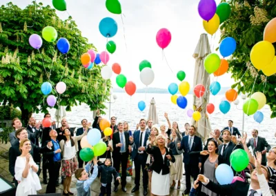 Hochzeit in Starnberg: Gaeste lassen farbige Luftballons fliegen, Feier am Ufer des Starnberger Sees, Trauungsreportage.