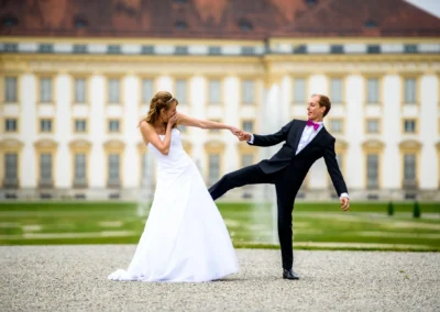 Brautpaar lacht vor Schloss Schleissheim bei Hochzeit, fröhliche Momentaufnahme der Trauung nördlich von Muenchen.