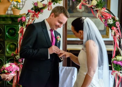 Bräutigam steckt der Braut den Ring an, Hochzeit in Seefeld, Trauung, festliche Atmosphäre, Hochzeitsreportage.