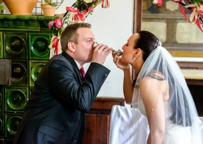 Junges Paar trinkt bei Hochzeit im Schloss Seefeld symbolisch aus Kelchen. Hochzeitsreportage in der Naehe des Pilsensee.