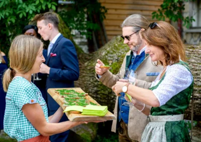 Hochzeitsgesellschaft geniesst Aperitif im Freien beim Hasenoehrlhof, Geitau, Bayrischzell.