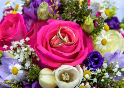 Blumenstrauss mit Eheringen auf einer Rose bei einer Hochzeit in Aufhausen, perfekte Kulisse fuer Trauung und Reportage.