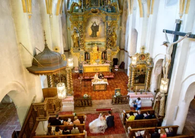 Hochzeit in Kirche auf der Fraueninsel, stilvoll dekorierter Altar, Brautpaar bei der Trauung.