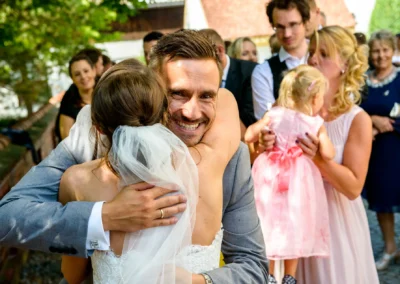 Brautpaar bei kirchlicher Hochzeit in St. Martin Germering nahe Muenchen, umgeben von Feiernden.