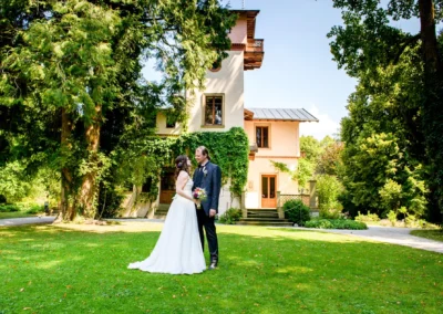 Brautpaar auf Roseninsel Starnberger See, romantisches Shooting vor historischem Gebaeude und gruenem Garten.