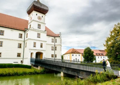 Brautpaar auf Bruecke vor Schloss Hohenkammer, perfekte Kulisse fuer eine Hochzeitsreportage und romantische Trauungen.