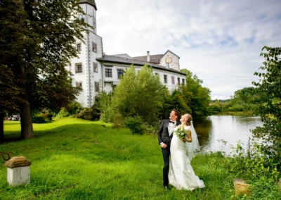 Brautpaar bei Hochzeit im Schlossgarten von Schloss Pertenstein, Traunreut, umgeben von Natur und See.