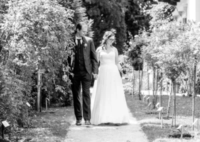 Brautpaar-Shooting auf der Roseninsel am Starnberger See, romantischer Spaziergang zwischen blumigen Gartenwegen.