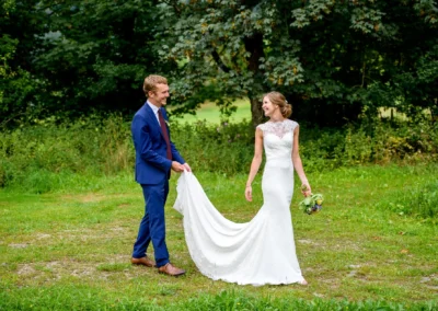 Brautpaar Fotoshooting im Hasenoehrlhof, Geitau: Glueckliches Paar in eleganter Hochzeitskleidung im Gruenen.