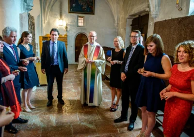 Priester bei einer Trauung mit Gaesten auf der Fraueninsel. Feierliche Zeremonie in historischer Kirche.