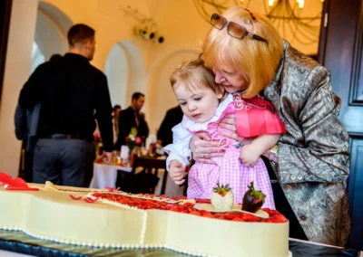 Großmutter und Kind betrachten Hochzeitstorte auf Trauung in Seefeld, nahe Pilsensee, Hochzeitsreportage.