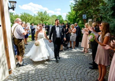Brautpaar verlaesst Kirche St. Martin Germering bei Muenchen nach kirchlicher Trauung, Gaeste applaudieren.